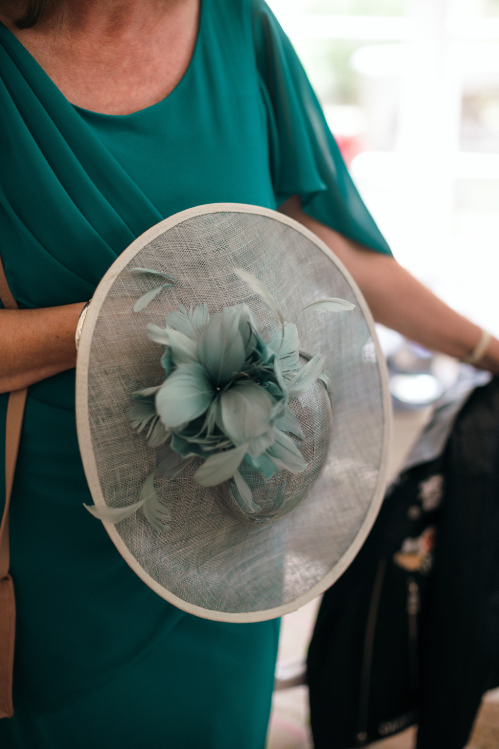 Bridesmaid holds hat