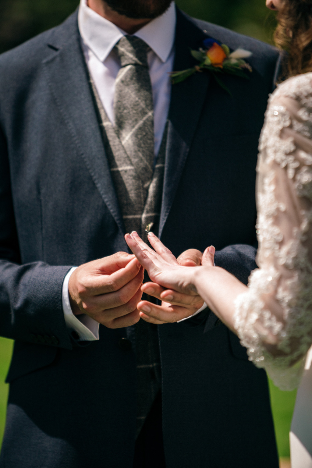 Groom puts wedding band/ring on brides finger
