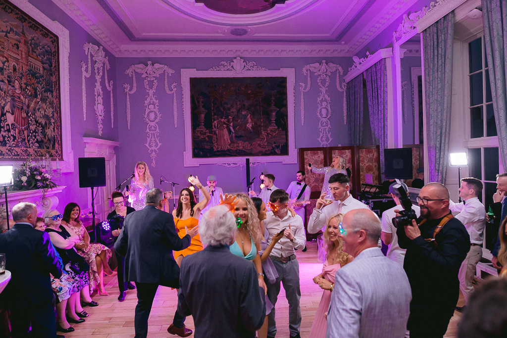 Pink hue dancefloor bride groom and guests